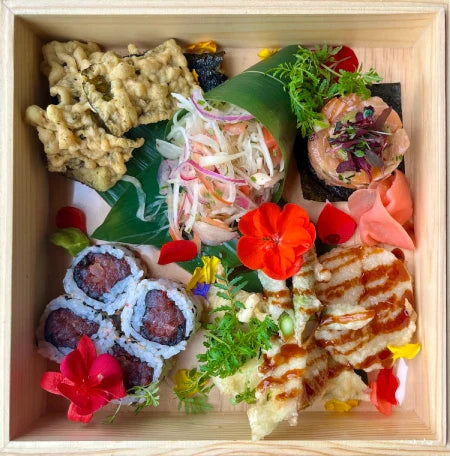 Boîte de sushis gourmets avec tartare de saumon, salade et craquelins aux algues